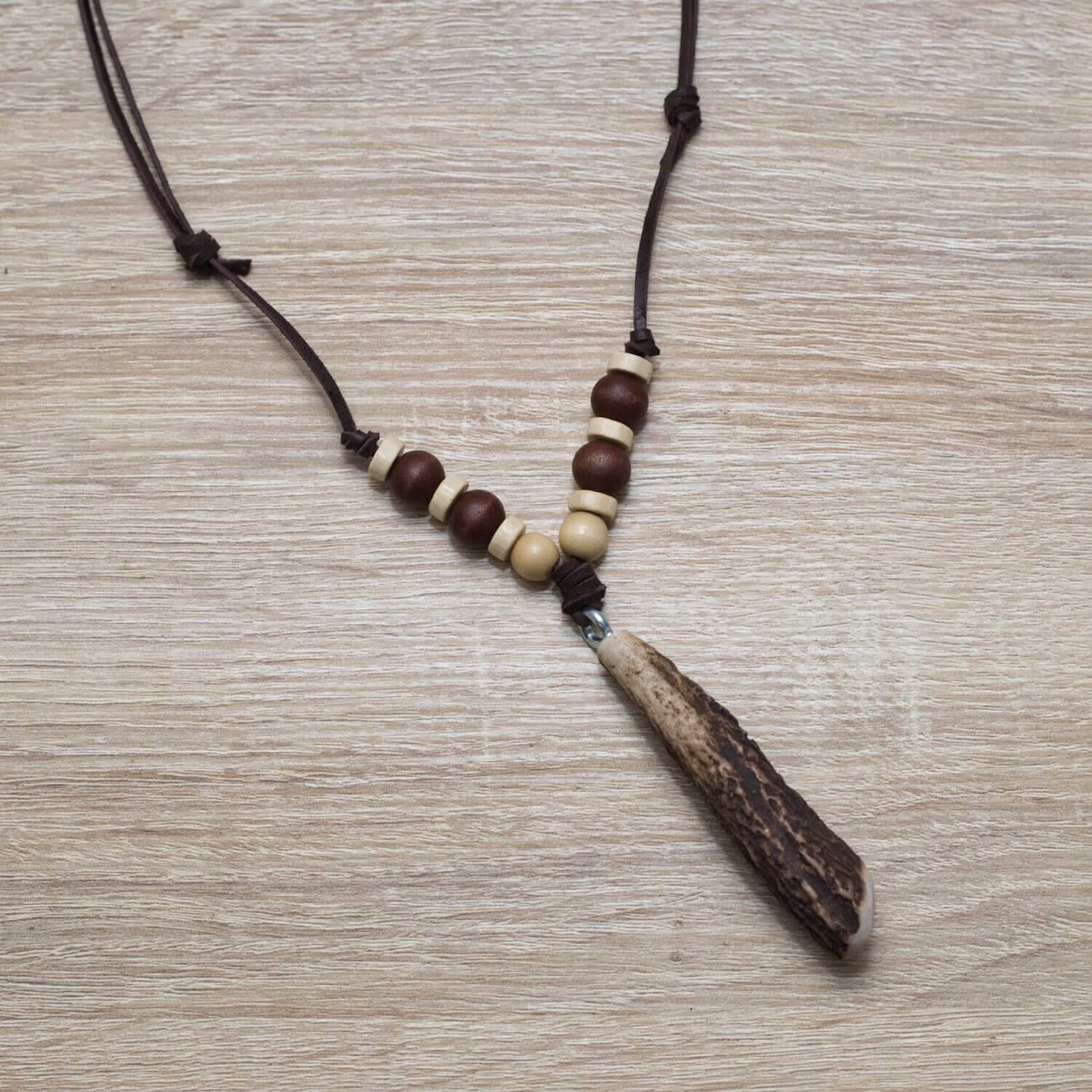 Náhrdelník vyrobený z parožia jeleňa a drevených korálok na koženej šnúrke.